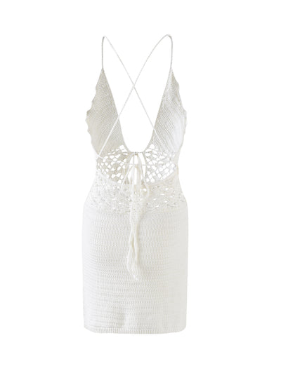 The ISABELL DRESS - WHITE from TIGERMIST is a stunning white crochet mini dress that showcases a deep V-neckline, delicate spaghetti straps that crisscross at the back, and an intricate cut-out pattern at the waist. The dress has a form-fitting silhouette and features a back tie with a string for added detail.
