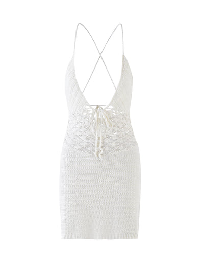 The ISABELL DRESS - WHITE from TIGERMIST is a mid-length white knitted dress featuring a plunging neckline, thin spaghetti straps that crisscross at the back, and a decorative lace-up detail at the waist. The dress showcases a textured pattern with intricate weave at the bodice and a tighter knit at the skirt.