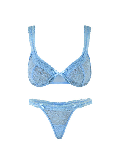 The PANDORA SET - BLUE by TIGERMIST is a matching ensemble of light blue lace lingerie, featuring intricate lace detailing and small satin bows at the center of the bra. The thong, made with sheer mesh and complementary patterns, also has a matching bow at the front. Both pieces are delicate and feminine in design.