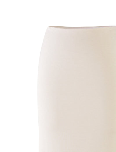 A close-up image of the backrest of an off-white KAROLINA JERSEY SKIRT by TIGERMIST, highlighting its smooth, minimalist design against a white background. The skirt exhibits a slightly curved silhouette, presenting a modern and elegant aesthetic.