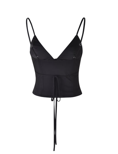 The KATINA CAMI - BLACK by TIGERMIST is a sleeveless crop top featuring thin spaghetti straps and a plunging V-neckline. This piece includes a front tie detail at the waist, adding a stylish element to its design.