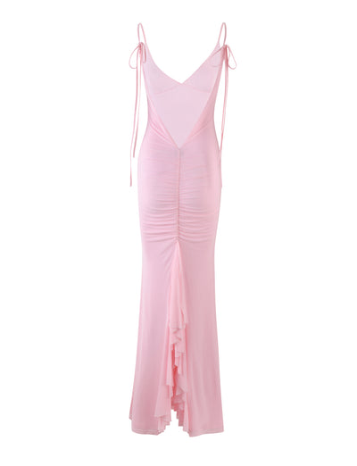 The KYLAH DRESS - PINK : BABY PINK by TIGERMIST is a long dress with spaghetti straps and a deep V back. It features a fitted bodice with ruching down the center, creating a textured effect. The skirt flares out slightly at the bottom, ending in a layered, ruffled hem.
