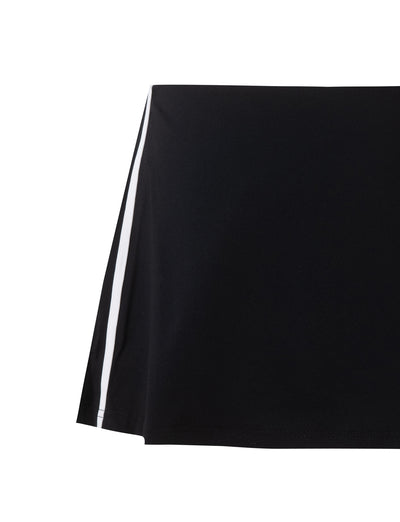 A close-up of the ELESSAR SKORT - BLACK by TIGERMIST reveals a smooth, high-quality fabric featuring a clean and sharp black base with a white vertical stripe on one side, indicating it is part of an exquisite garment.