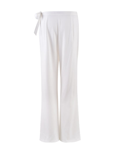 Introducing the TRISTAN PANT - WHITE from TIGERMIST: A pair of white, loose-fitting pants with a straight-leg silhouette and a tie-waist detail on the left side. Crafted from soft, flowy fabric, these pants maintain a minimalistic design without visible pockets or embellishments.