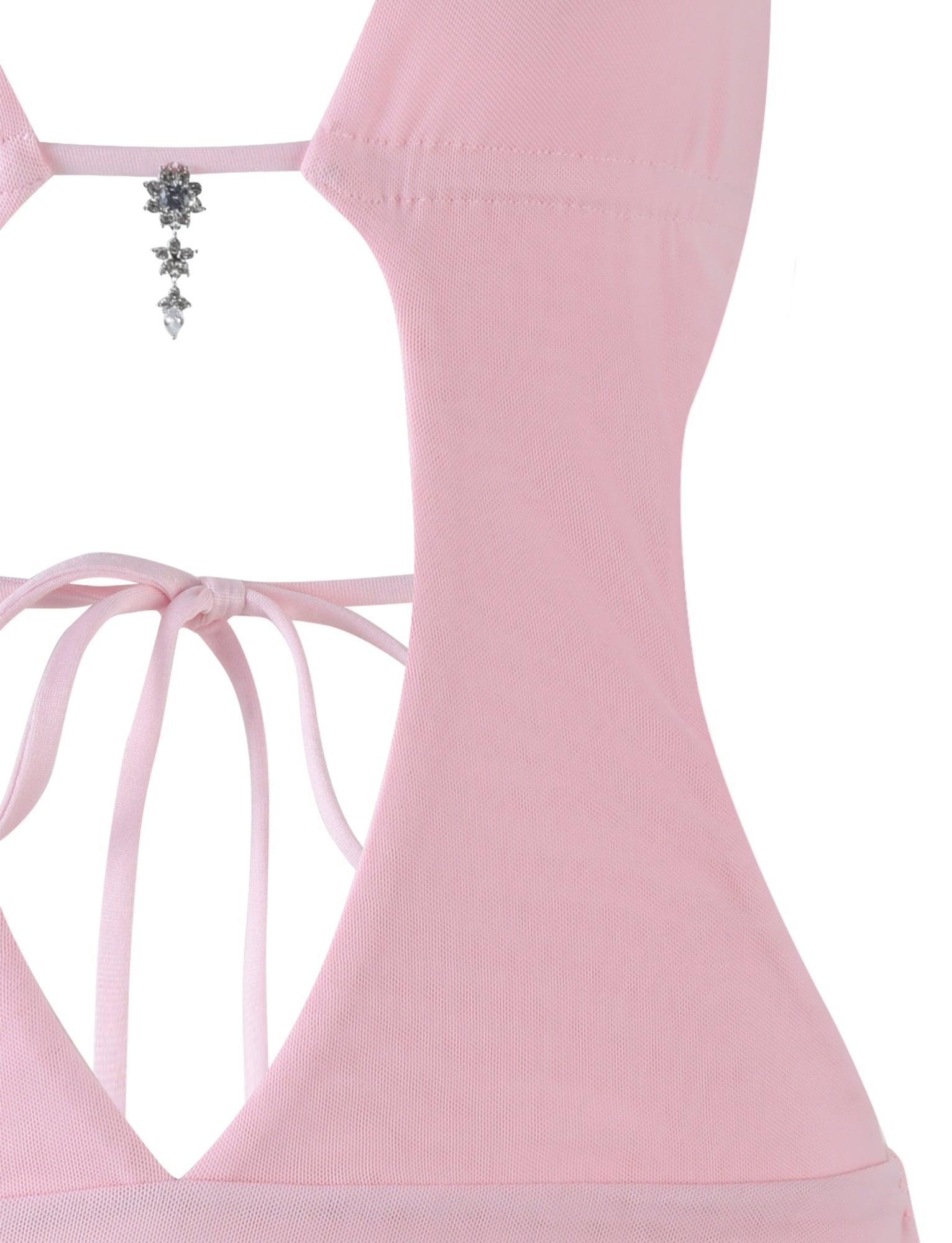 Close-up of the back of the TIGERMIST ESHA DRESS in Baby Pink, showing crisscross string ties, an open back with a floral crystal charm at the neckline, and a figure-hugging bodycon silhouette.
