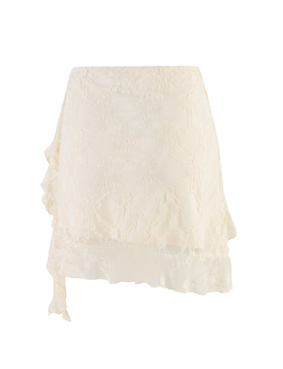 The STORMI LACE SKIRT by TIGERMIST in beige champagne lace features a scalloped hemline and an asymmetrical ruffle detail on the side, adorned with a delicate floral lace pattern that imparts a feminine and elegant look.