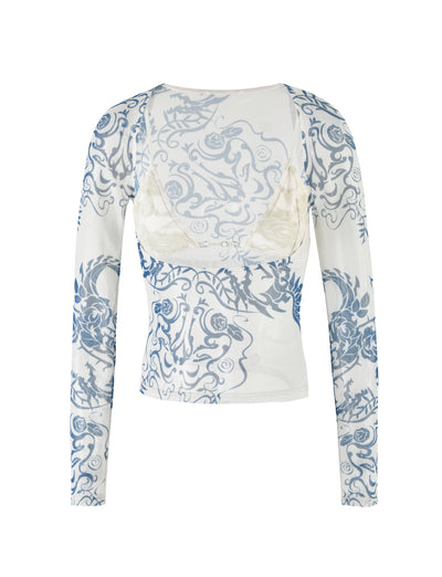 The CHRISTY MESH LONG SLEEVE TOP - BLUE : TATTOO : TATTOO PRINT from TIGERMIST features a low neckline and elegant blue baroque patterns on a white background. The sheer top partially reveals a white bra underneath, with both the front and back showcasing its intricate design. The material is delicate yet stylish, making it a standout piece.