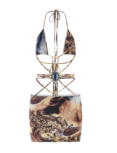 A striking TigerMist dress called the Marcel boasts a tie-dye paisley pattern in earthy tones of brown and beige. This intricately designed piece features a halter neck with a central ornamental jewel, along with elaborate cutouts and strappy details.