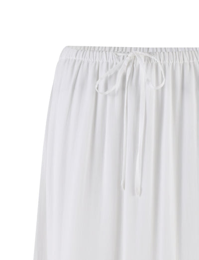 A close-up view of the PHILLIPA SKIRT - WHITE from TIGERMIST, showcasing its gathered elastic waistband with a drawstring tied in a bow. The fabric appears lightweight and slightly pleated.