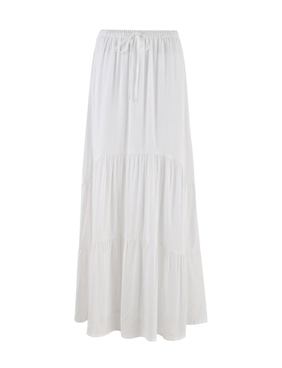 The PHILLIPA SKIRT - WHITE from TIGERMIST is a flowing white skirt with a drawstring waistband. It boasts a tiered design, offering both casual and elegant appeal. The lightweight fabric makes it perfect for warm weather.