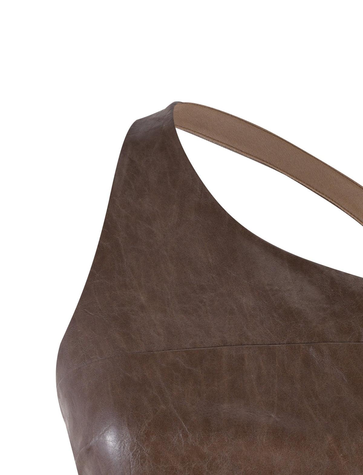 Close-up image of the TIGERMIST ZOYA TOP - BROWN, featuring a sleeveless design and an asymmetrical neckline. The texture of the leather is visible, showcasing a smooth yet rugged appearance. The top appears to be flat laid, focusing primarily on the upper section.
