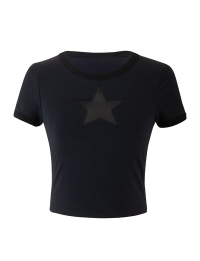 The BILLIE TEE from TIGERMIST is a black, short-sleeved crop top with a round neckline. It has a star-shaped cutout in the center of the chest area, and the edges of the neckline and sleeves are slightly darker, providing a subtle contrast to the design.
