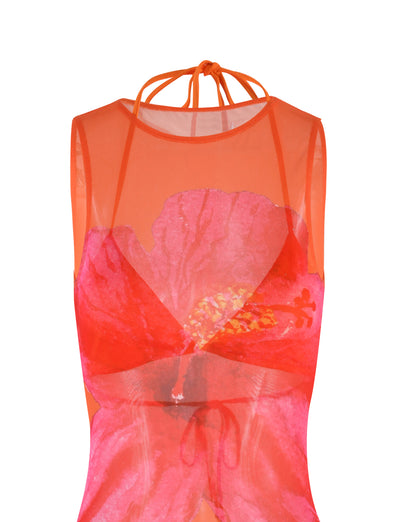 The JOZIE THREE PIECE DRESS - ORANGE : MACRO FLORAL : ORANGE HIBISCUS from TIGERMIST is a sleeveless, sheer orange top with a halter neck tie, featuring a vibrant pink and red floral design on the front. The fabric appears light and flowy, and the floral print adds a bold and colorful focal point to the garment.