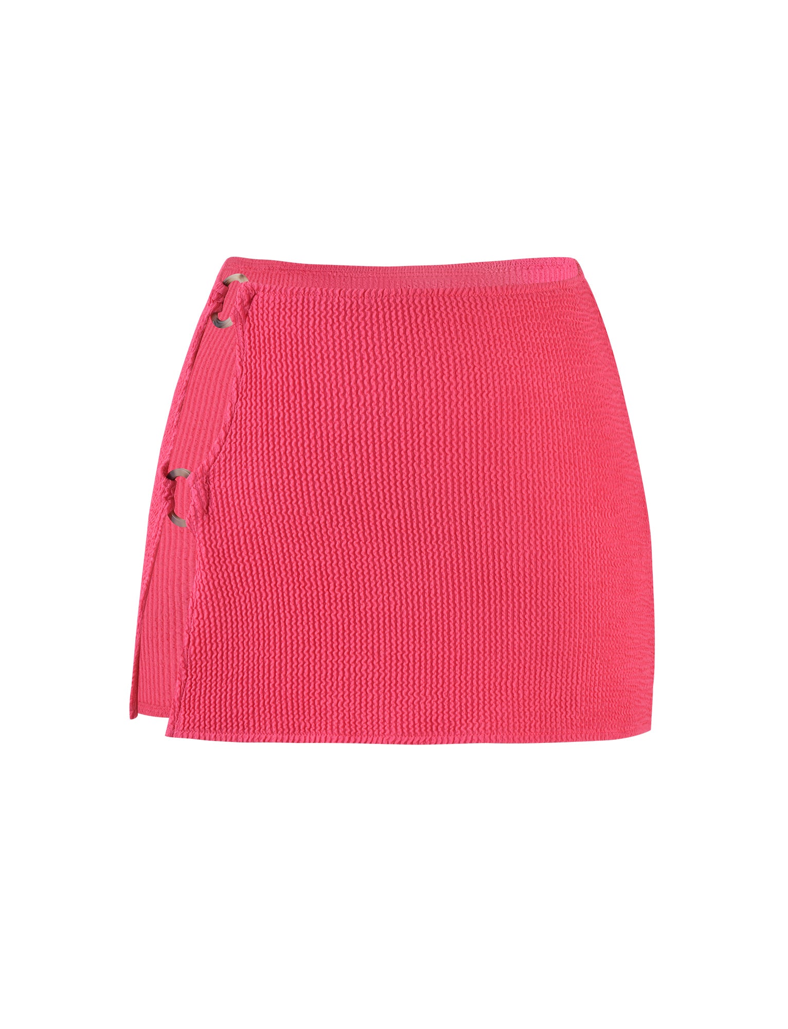 The NEERA MINI SKIRT - PINK : HOT PINK : FUCHSIA from TIGERMIST is a vibrant, bright pink textured mini skirt featuring a wrap design with two metal ring closures on the left side and a slight slit at the hem near the closures, adding a stylish touch.
