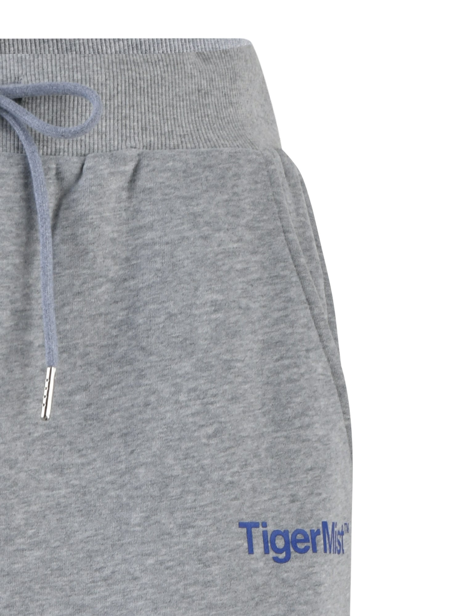 Close-up of a pair of LUMEN PANT - GREY featuring an elastic waistband with a drawstring tie. The right side of the sweatpants boasts the brand name "TIGERMIST" printed in blue text near the pocket.