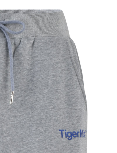 Close-up of a pair of LUMEN PANT - GREY featuring an elastic waistband with a drawstring tie. The right side of the sweatpants boasts the brand name "TIGERMIST" printed in blue text near the pocket.