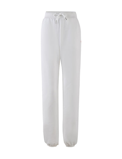 The LUMEN PANT in white by TIGERMIST is a pair of mid-rise loungewear pants featuring an elastic waistband and drawstring tie. These sweatpants offer a relaxed fit with tapered legs and elastic cuffs at the ankles, creating an oversized trackpant silhouette. They also include subtle seam pockets on each side.