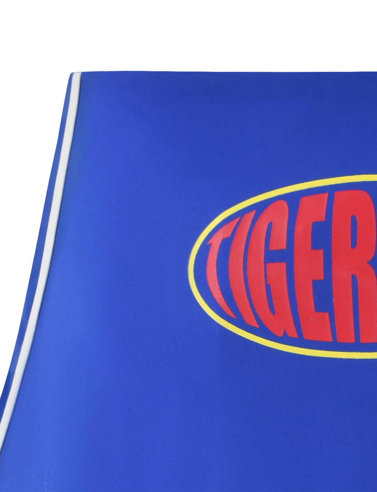 Close-up of the blue fabric from the DELANEY SKORT - BLUE, with a partial view of an oval-shaped emblem. The emblem features a yellow outline and bold, uppercase red letters "TIGERMIST" on a blue background, reminiscent of Tiger Mist designs. A thin white stripe runs along the edge of the fabric.