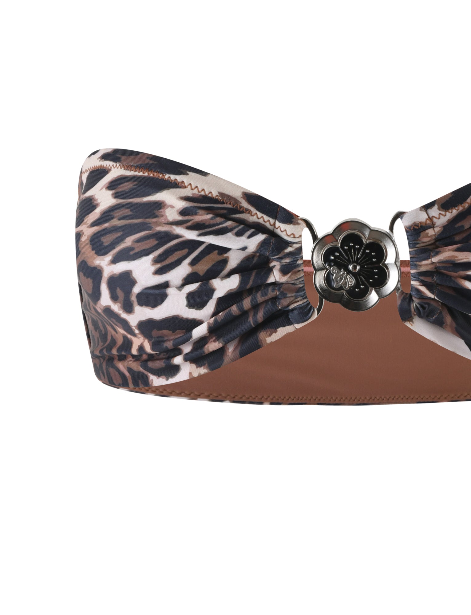 The TIGERMIST CYNTHIA BIKINI TOP - MULTI: LEOPARD is a strapless bandeau bikini top featuring a striking brown, black, and white leopard print. The center showcases a silver floral metal embellishment surrounded by gathered fabric to create a ruched effect.