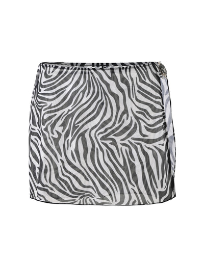 Check out the TIGERMIST Cynthia Mini Mesh Skirt in Black Zebra, a chic short skirt featuring a bold black and white zebra print design. This stylish wrap-around skirt has a slight overlap on one side with a buckle detail at the top for added flair. Made from lightweight, semi-sheer fabric, it's perfect for any fashionable outfit.