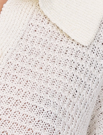 Close-up of the TIGERMIST JANAI TOP in white, showcasing its intricate, textured pattern. The image captures part of a V-neckline and collar, adding to the garment's overall detail and design.