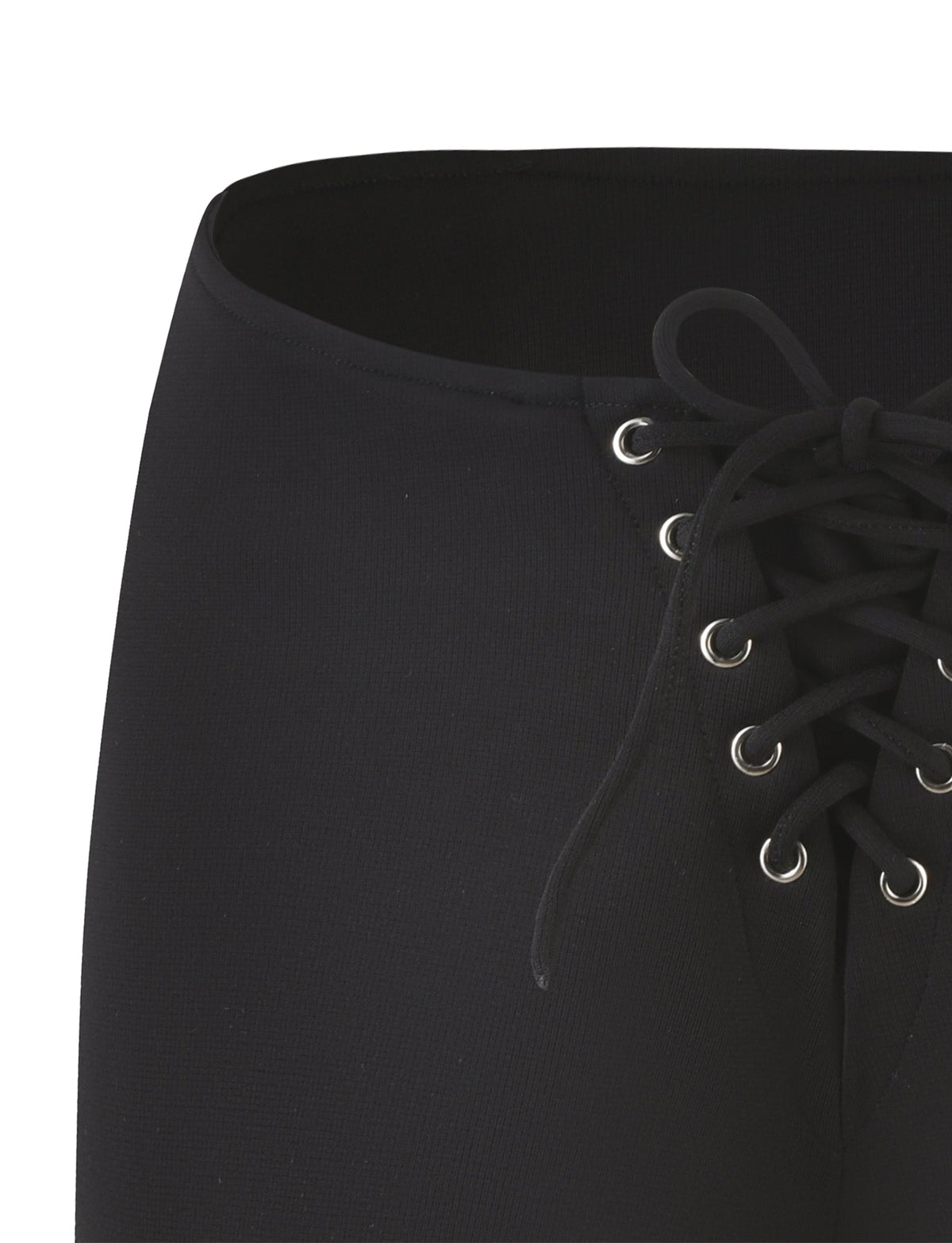 A close-up of the ELERI SHORT - BLACK by TIGERMIST showcases a sleek micro short with an eye-catching lace-up design, complete with metal eyelets and black laces tied in a bow. The fabric has a slightly textured appearance, and the centrally-placed lace-up detail accentuates its bodycon silhouette.