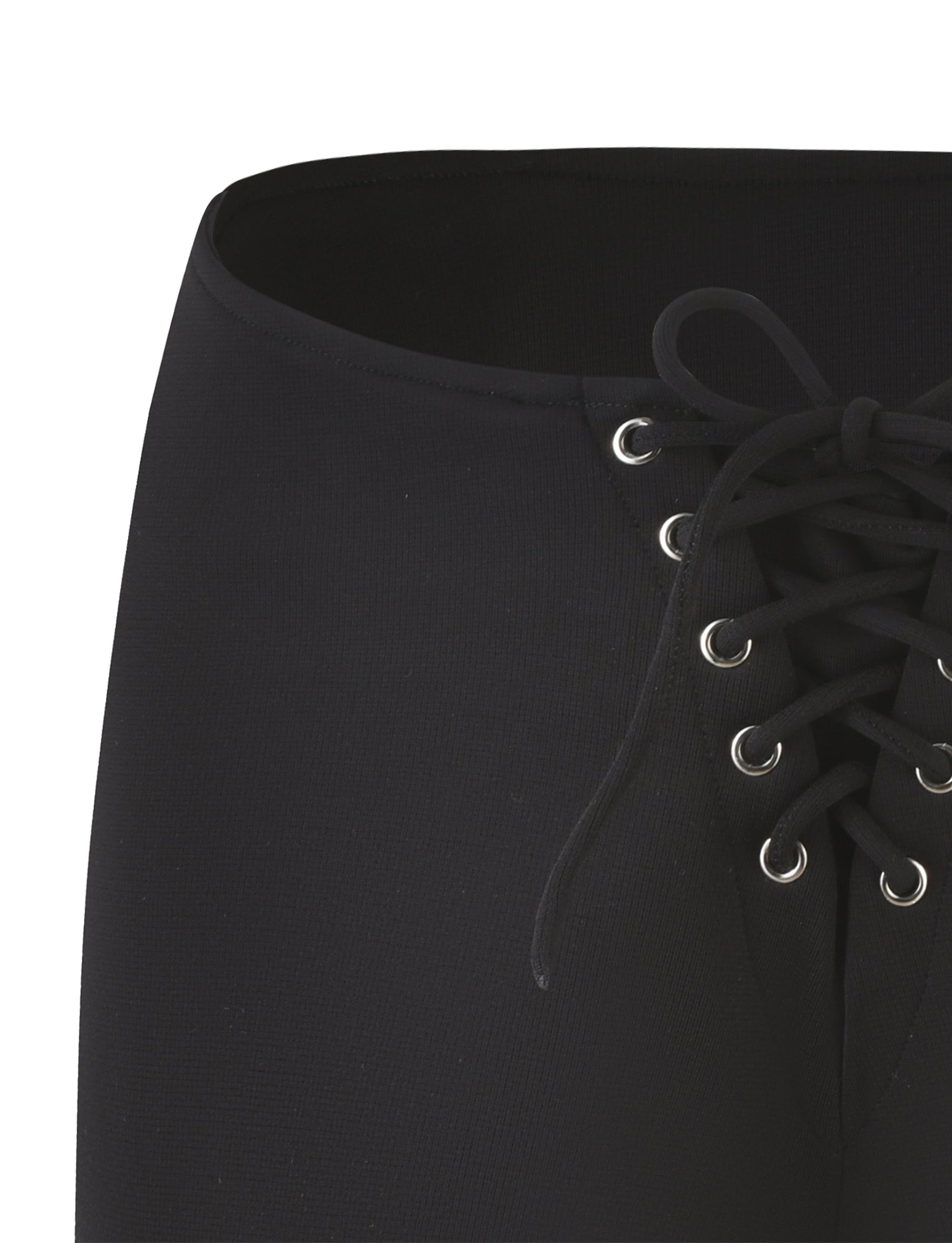 A close-up of the ELERI SHORT - BLACK by TIGERMIST showcases a sleek micro short with an eye-catching lace-up design, complete with metal eyelets and black laces tied in a bow. The fabric has a slightly textured appearance, and the centrally-placed lace-up detail accentuates its bodycon silhouette.