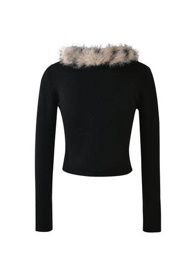 The DARJA CARDIGAN - BLACK by TIGERMIST features long sleeves, a cropped fit, and a fluffy faux fur collar with white, black, and gray speckles. The sweater is displayed against a plain white background.