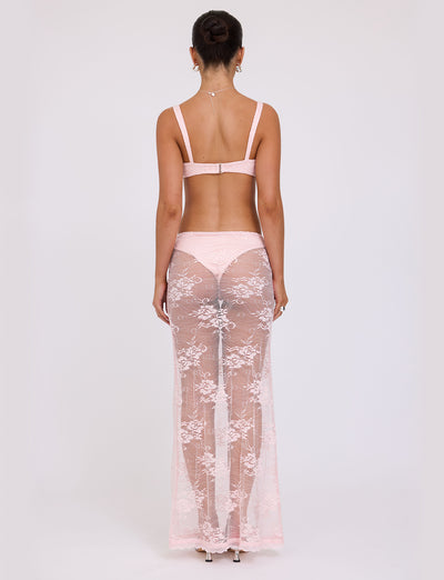 A woman is standing with her back to the camera, modeling the XADIE TOP from TIGERMIST in pale pink, along with matching sheer lace pants. Her hair is tied up in a bun as she poses against a plain white background.
