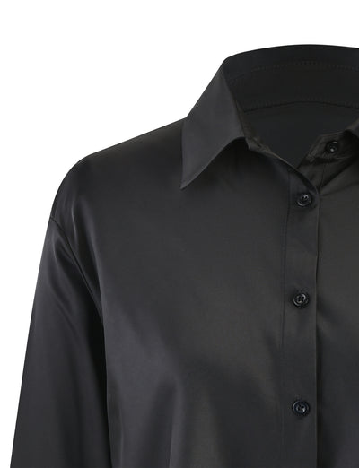 Close-up of the ALINA SHIRT - BLACK from TIGERMIST, focusing on the upper half. The shirt features a classic collar and is crafted from a smooth, slightly shiny fabric. Four black buttons are visible from the chest to the collar. The sleeve on the left side is partially shown.