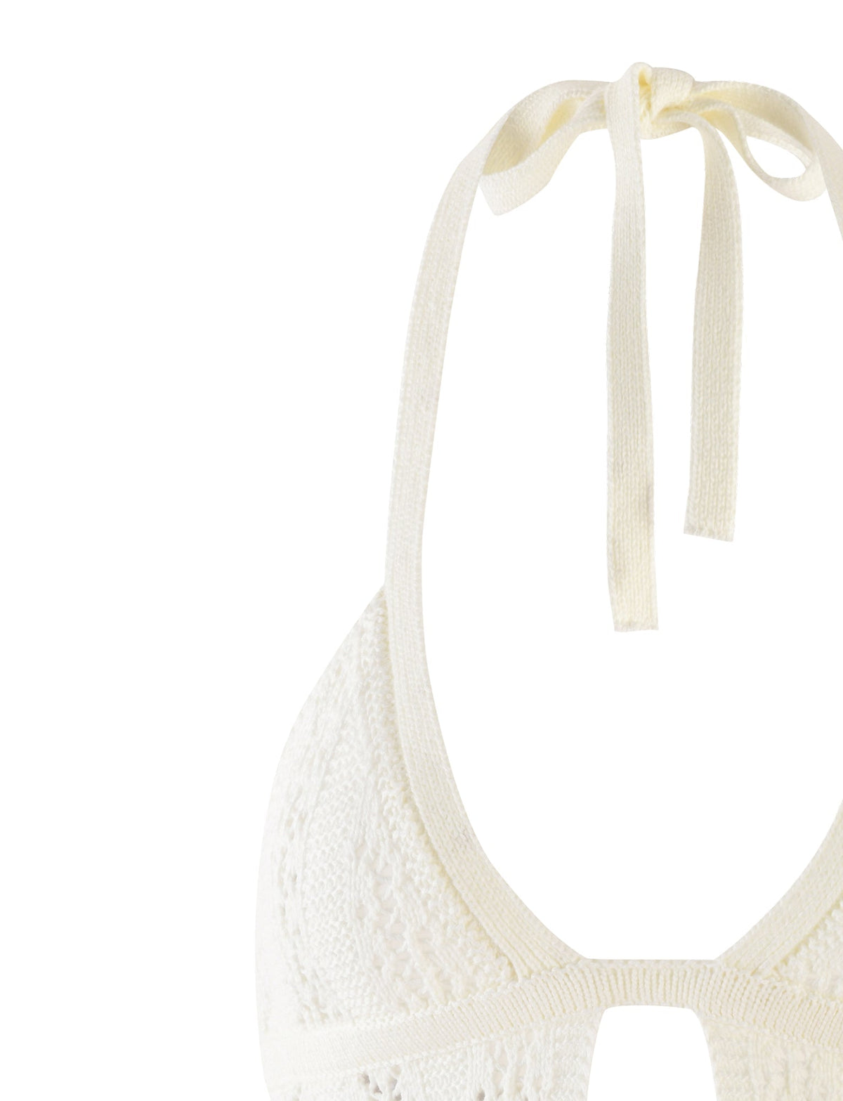 A close-up image of the upper part of the SANDOR TOP - WHITE by TIGERMIST. The top features a delicate, textured knit pattern and ties at the neck with a bow. The fabric appears soft, and the design includes a small cutout at the base of the neckline.