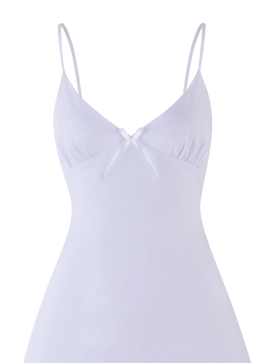 The WINNIE MINI DRESS - WHITE by TIGERMIST features a sleeveless design, adjustable shoulder straps, a V-neckline, soft gathers under the bust, and a small decorative bow at the center front.