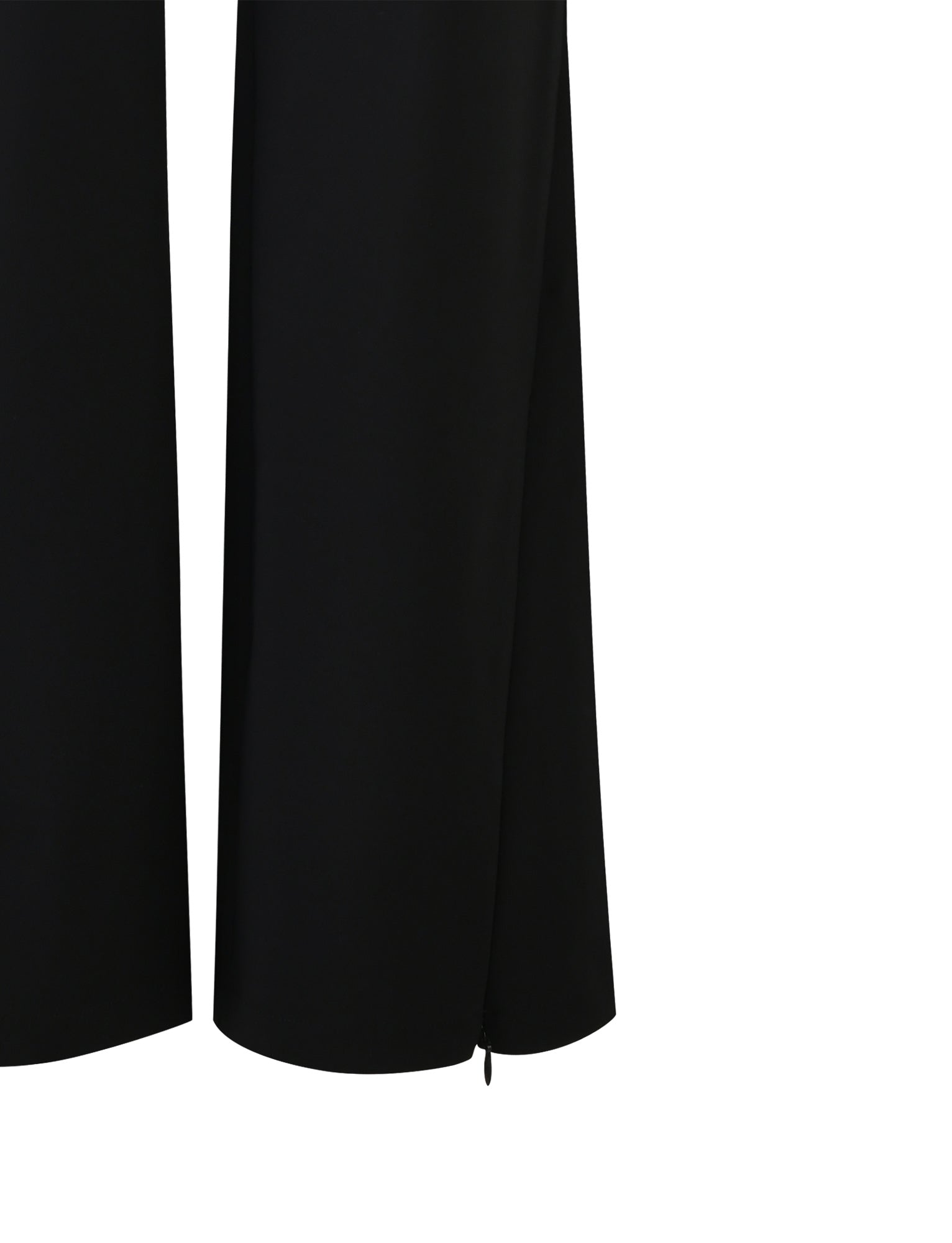 A close-up image captures the lower portion of the DAMIRA PANT - BLACK from TIGERMIST, showcasing the fabric and wide-leg flare at the bottom. The pants are plain with no visible patterns or embellishments.