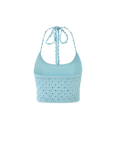 SUNNIVA Bikini Top in Baby Blue by TIGERMIST boasts a light blue knit fabric and features spaghetti strap halter neckline. The lower half is adorned with an intricate crocheted pattern, while the upper part showcases a smooth, solid texture. The halter straps elegantly tie at the back of the neck.