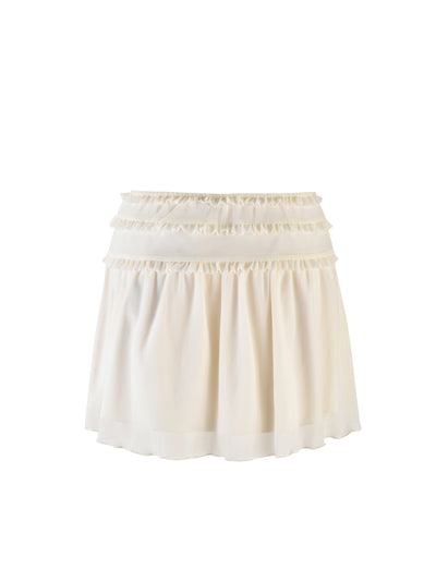 A white short skirt with a ruffled design is displayed on a plain white background. The TIGERMIST Ginny Skirt features three horizontal ruffle layers at the top, adding texture and volume. The fabric appears lightweight and flowy, creating a soft and elegant look.