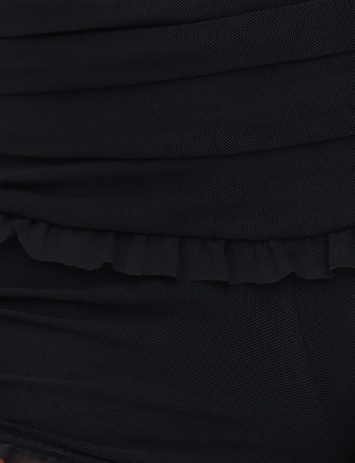 Close-up of the GINNY SHORT - BLACK by TIGERMIST, featuring black textured fabric with horizontal pleats and subtle ruffle details along the edge for a layered, wavy look.