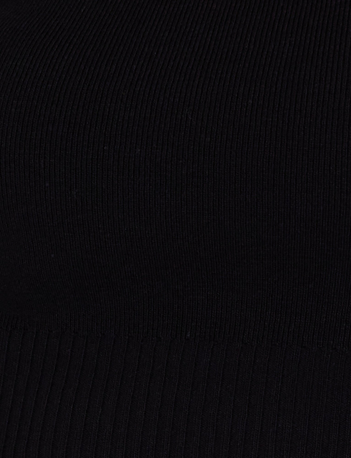 Close-up of the LEDGER CAPRI - BLACK by TIGERMIST, featuring a ribbed fabric with vertical lines and a textured surface. The material appears smooth and elastic, reminiscent of a bodycon fit, with subtle variations in the width of ribbing towards the bottom.