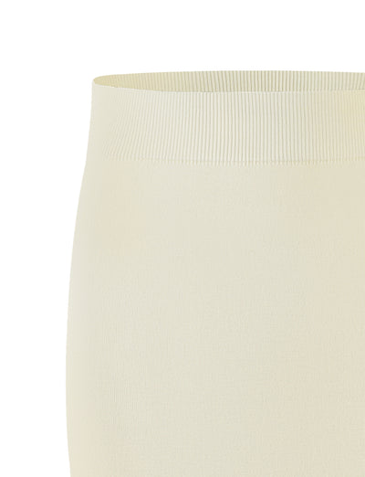 A close-up view of the LEDGER SKIRT - WHITE : CREAM from TIGERMIST showcases a light cream-colored, ribbed, high-waisted elastic waistband. The texture and stretchiness of the fabric are clearly visible, emphasizing the snug fit and smooth surface.