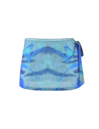 The TINSLEY SKORT - MULTI : ABSTRACT TIE DYE from TIGERMIST is a stylish blue-toned mini skirt featuring a vibrant abstract tie-dye pattern. It boasts a contemporary wrap design with a side tie at the waist, giving it a chic and modern appearance. The fabric looks lightweight and flowy, perfect for any occasion.