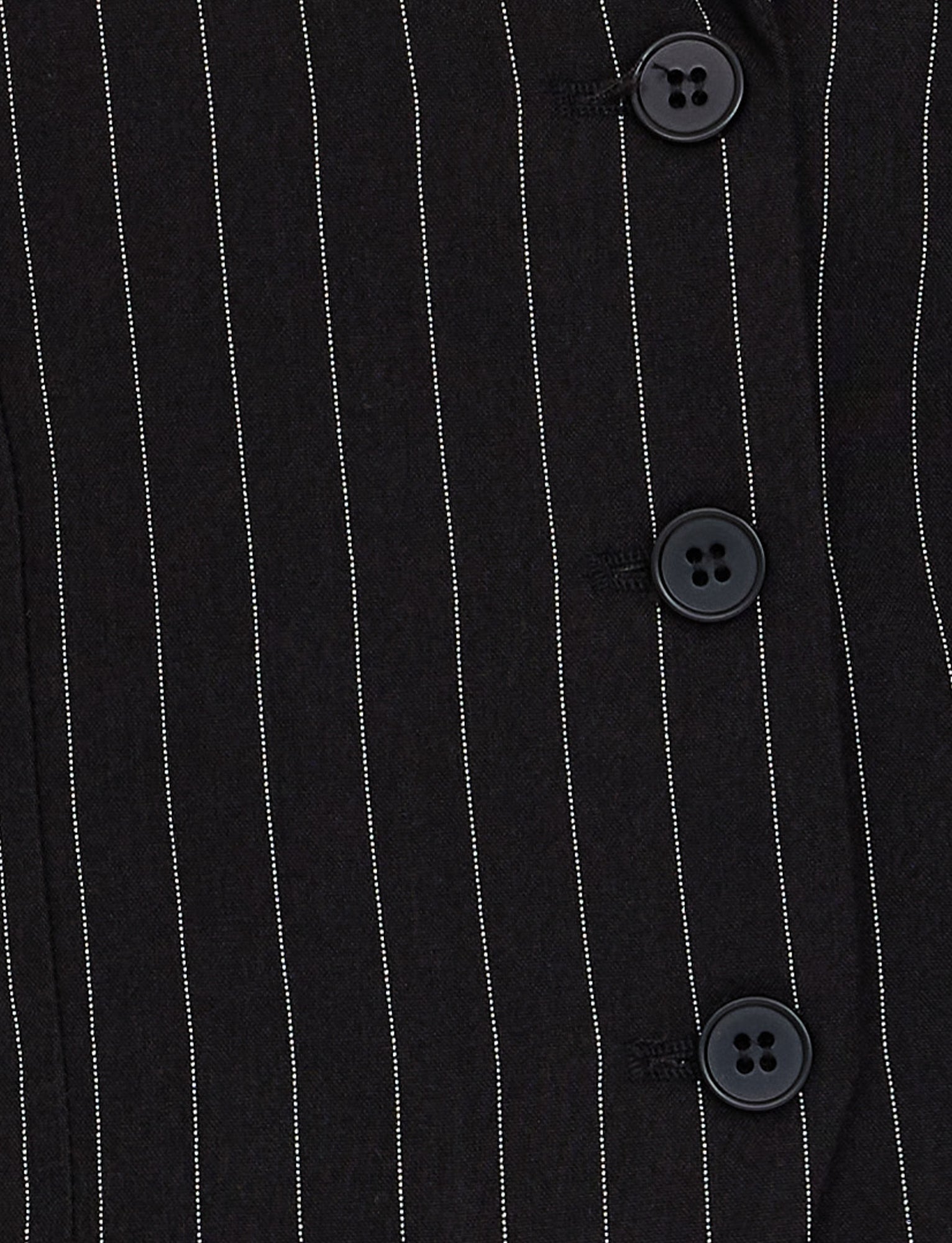 Close-up view of the TAMARA VEST - BLACK : PINSTRIPE by TIGERMIST, featuring a black pinstripe fabric with four black buttons along the right side. The vertical white stripes are evenly spaced, creating a classic pinstripe look.