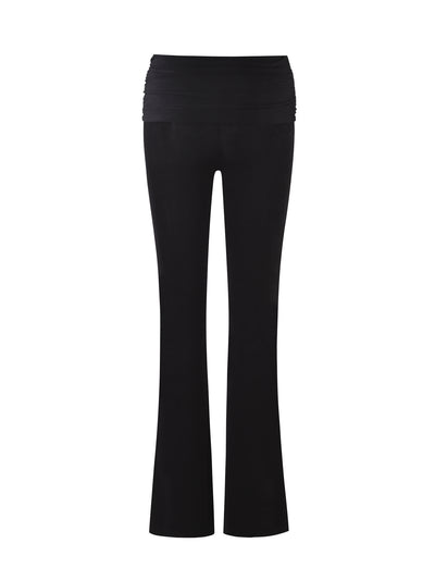 The MAKENA PANT - BLACK from TIGERMIST is shown against a white background. These women's yoga pants feature a high waist with a ruched band and flared legs. The material appears smooth and stretchy, making them ideal for exercise or casual wear.
