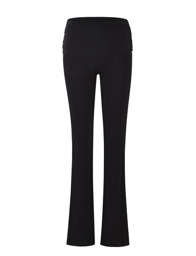 The MAKENA PANT - BLACK from TIGERMIST features a wide, high waistband for belly support and a bootcut leg style. The soft and stretchy fabric is designed to provide comfort during pregnancy, with ruched sides on the waistband.