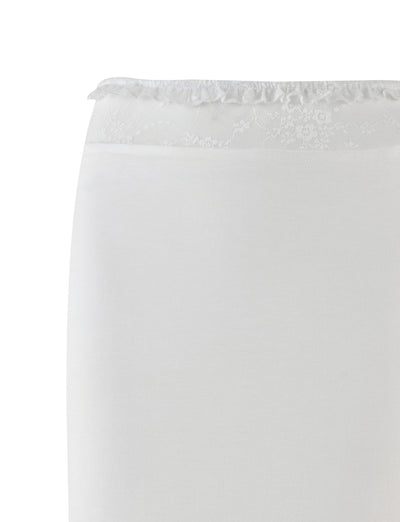 The BENTON SKIRT - WHITE by TIGERMIST features a white fabric with a delicate floral lace trim along the top edge, hinting at a refined lace waistband. The material has a smooth and slightly fitted appearance, suggesting elegance and sophistication. Set against a plain white background, this garment exemplifies simplicity and style in its design.
