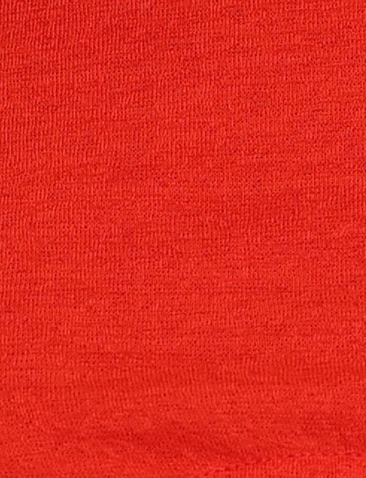 A close-up view of the PAXTON TOP - RED : OMBRE from TIGERMIST showcases a smooth, tightly woven fabric in a plain, solid red color reminiscent of a bodycon fit. The texture appears even, suggesting it may be made from cotton or a blend, with no visible patterns or designs.