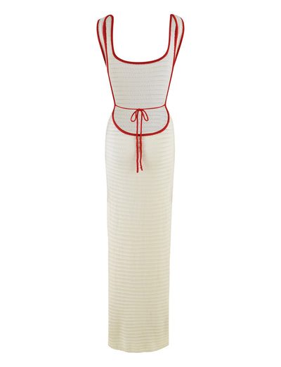 The MARLEIGH DRESS - WHITE by TIGERMIST is a long, sleeveless knit dress with a fitted silhouette featuring a cream color and red trim along the edges. It includes stylish details such as a scoop neckline and a red drawstring at the waist that ties in front. This elegant maxi-length dress offers an added touch of sophistication with its scoop neckline.