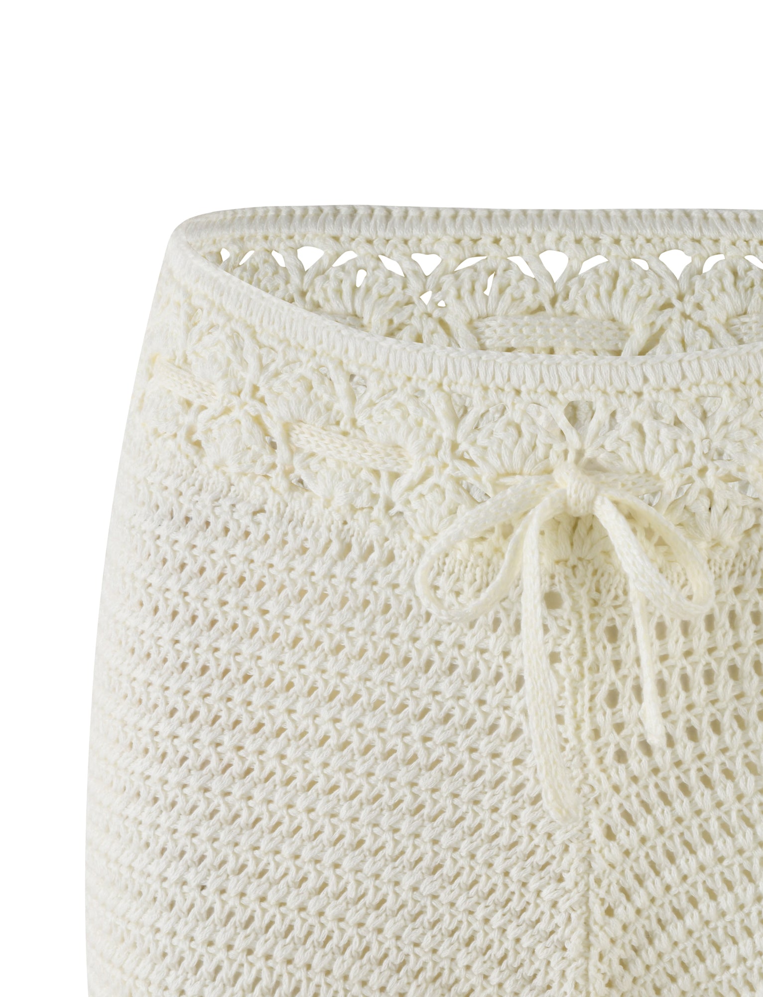 Close-up of the JONAS SHORT - WHITE : CREAM by TIGERMIST, showcasing the upper portion. The intricate knitted pattern features a decorative lace design near the waistband and a delicate drawstring tied in a bow at the front. The super mini length crochet work is detailed and textured, with contrast stitch accents.