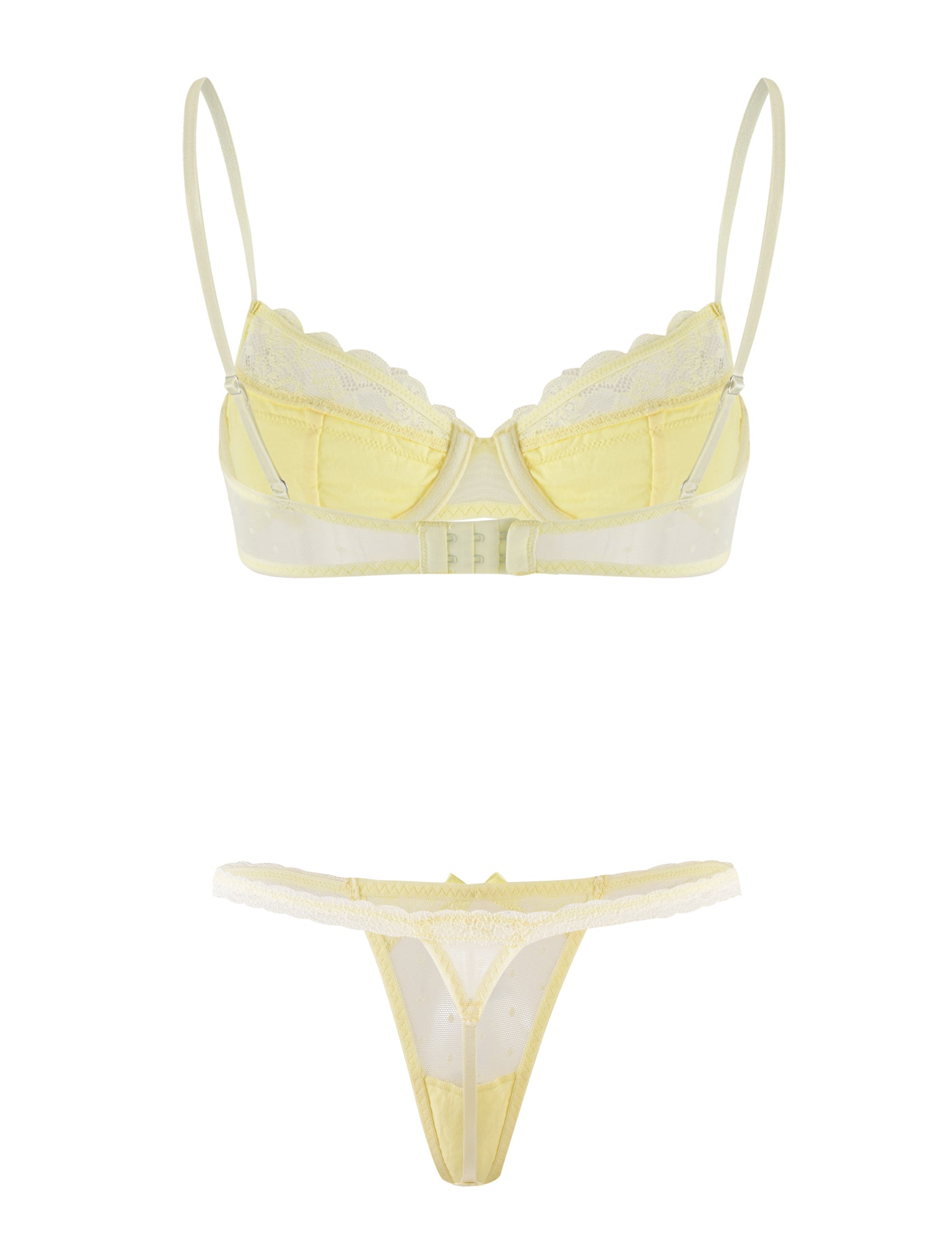 The SHAI SET - YELLOW : LEMON by TIGERMIST includes a light yellow lingerie set featuring a bra with adjustable shoulder straps and lace accents, paired with a matching thong. The bra has underwire cups and a clasp at the back, while the thong is designed with delicate lace trim, creating an elegant and delicate look.