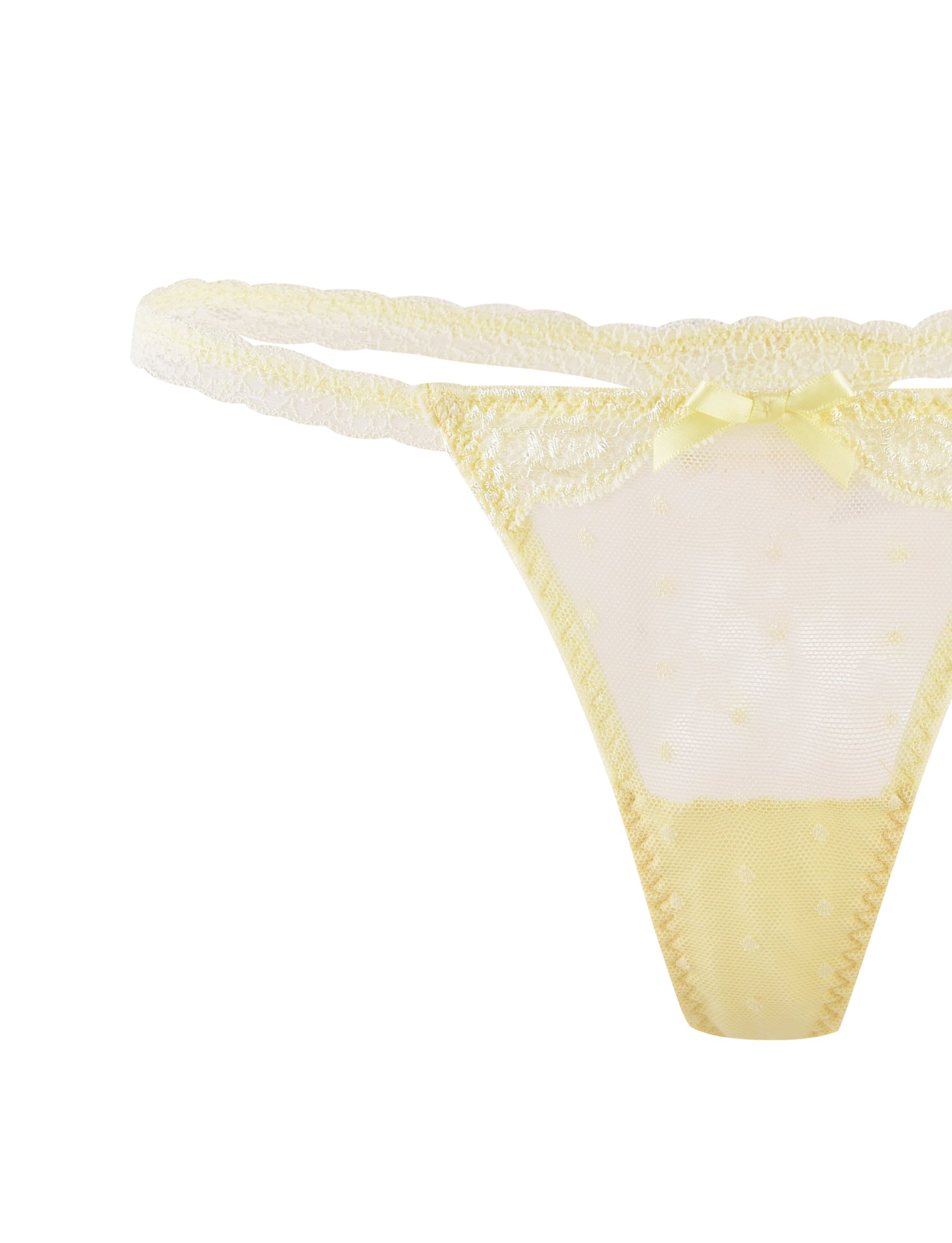 A close-up image of TIGERMIST's SHAI SET - YELLOW : LEMON, showcasing a pair of delicate, sheer, pale yellow lace panties adorned with tiny polka dots and a small satin bow at the front center. The waistband features matching lace trim. The overall design is feminine and elegant, perfect for pairing with the matching bra and G-string to complete the set.