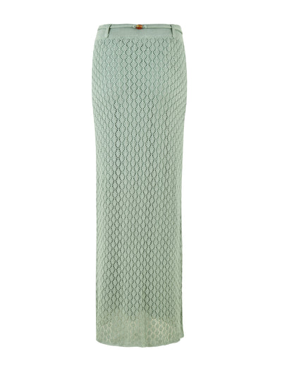 The image showcases the COLLINA SKIRT - GREEN from TIGERMIST, a stunning long light green crochet skirt with a fitted waistband and a small button detail. This elegant maxi-length piece features a delicate open-knit pattern and gracefully extends to the ankles, providing both breathability and sophistication.