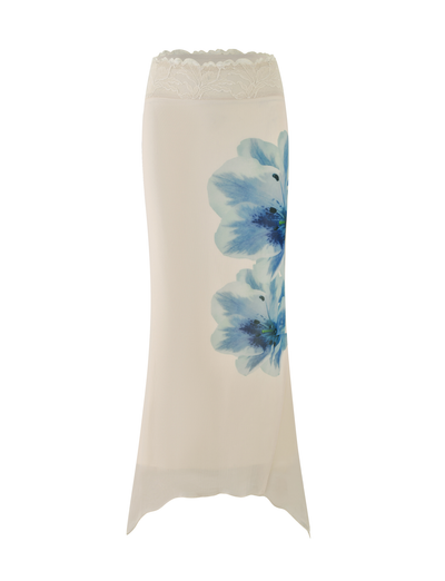 The LILLIAN SKIRT by TIGERMIST is a cream maxi skirt with a lace waistband and bold blue floral prints on the side, shown against a white background.